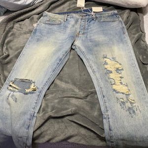 MNML blue men’s jeans with rips throughout